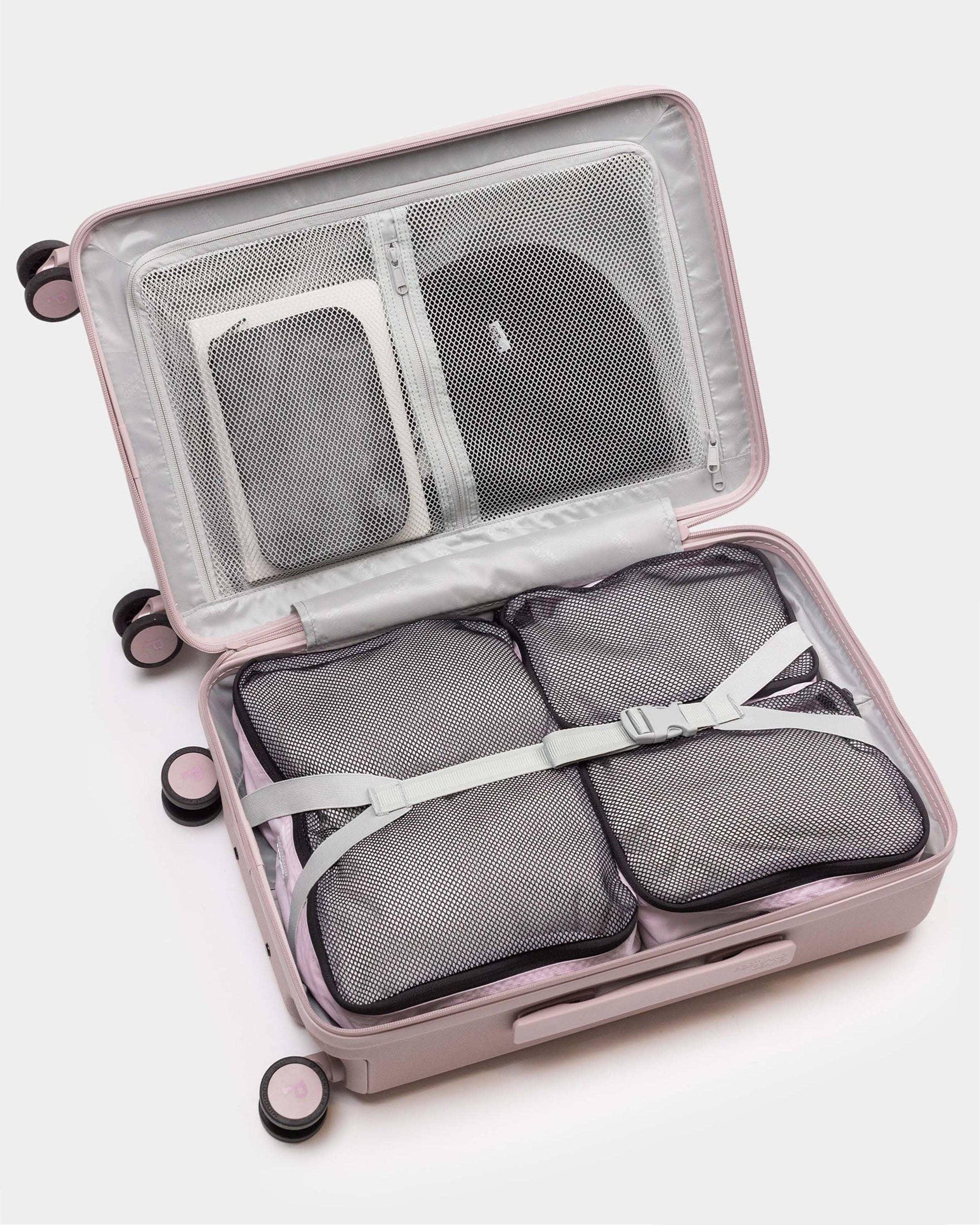 Open suitcase with packing cubes on a white background