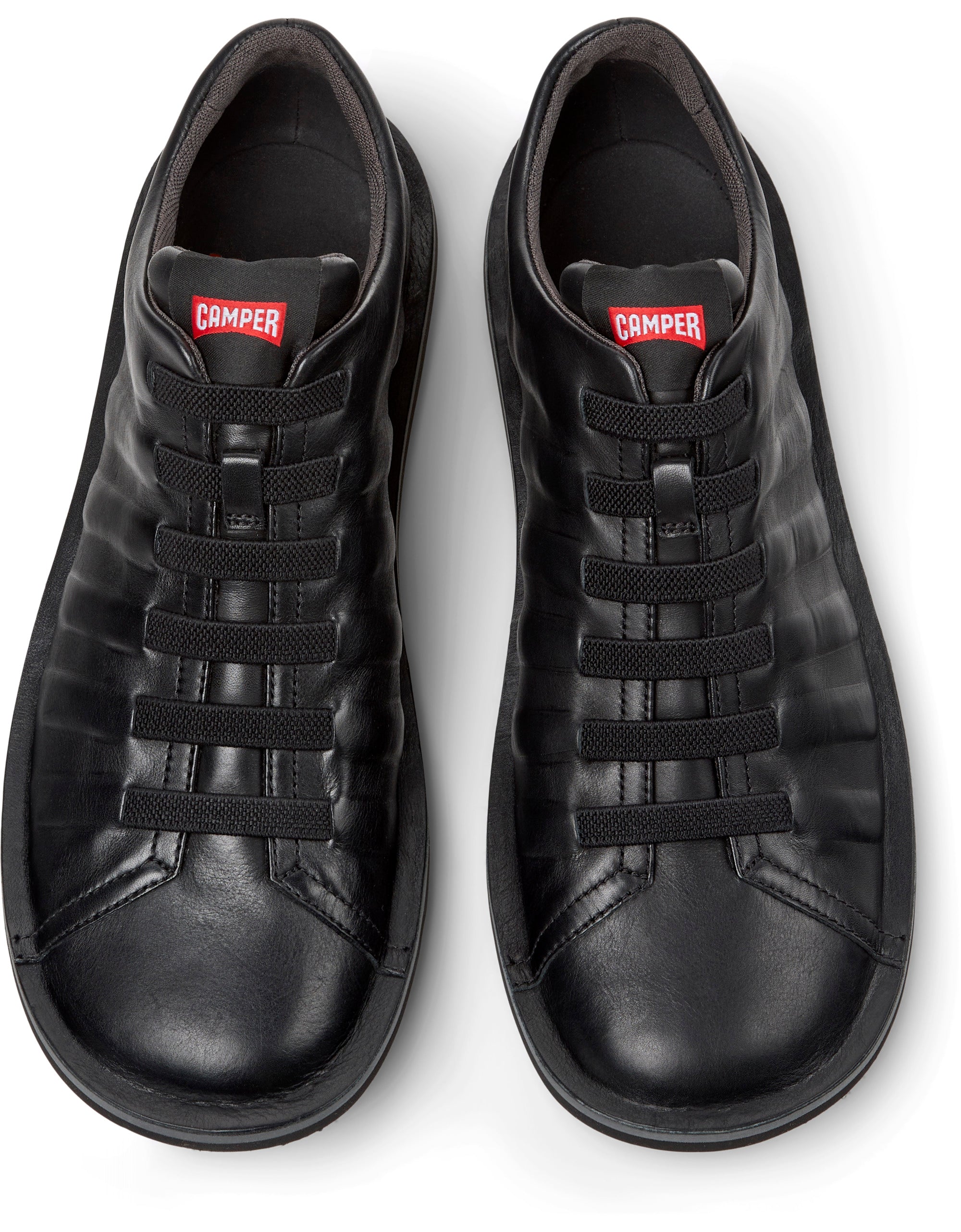 Pair of black sneakers with a visible brand logo on a white background