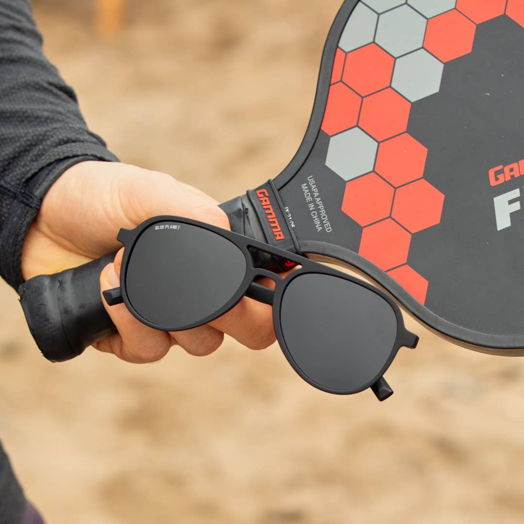 Black sunglasses with a hexagonal patterned object in the background
