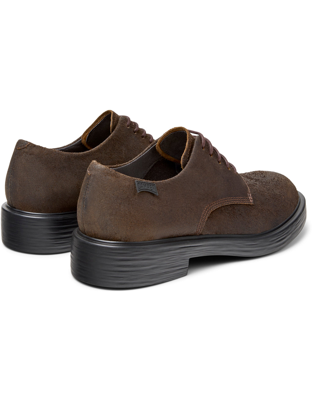 Brown suede shoes with black soles on a white background