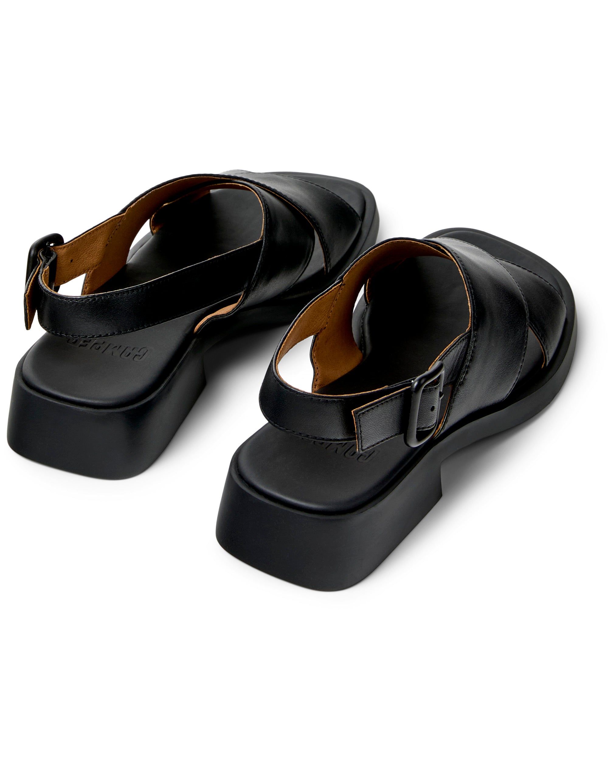 Pair of black sandals with buckles on a white background