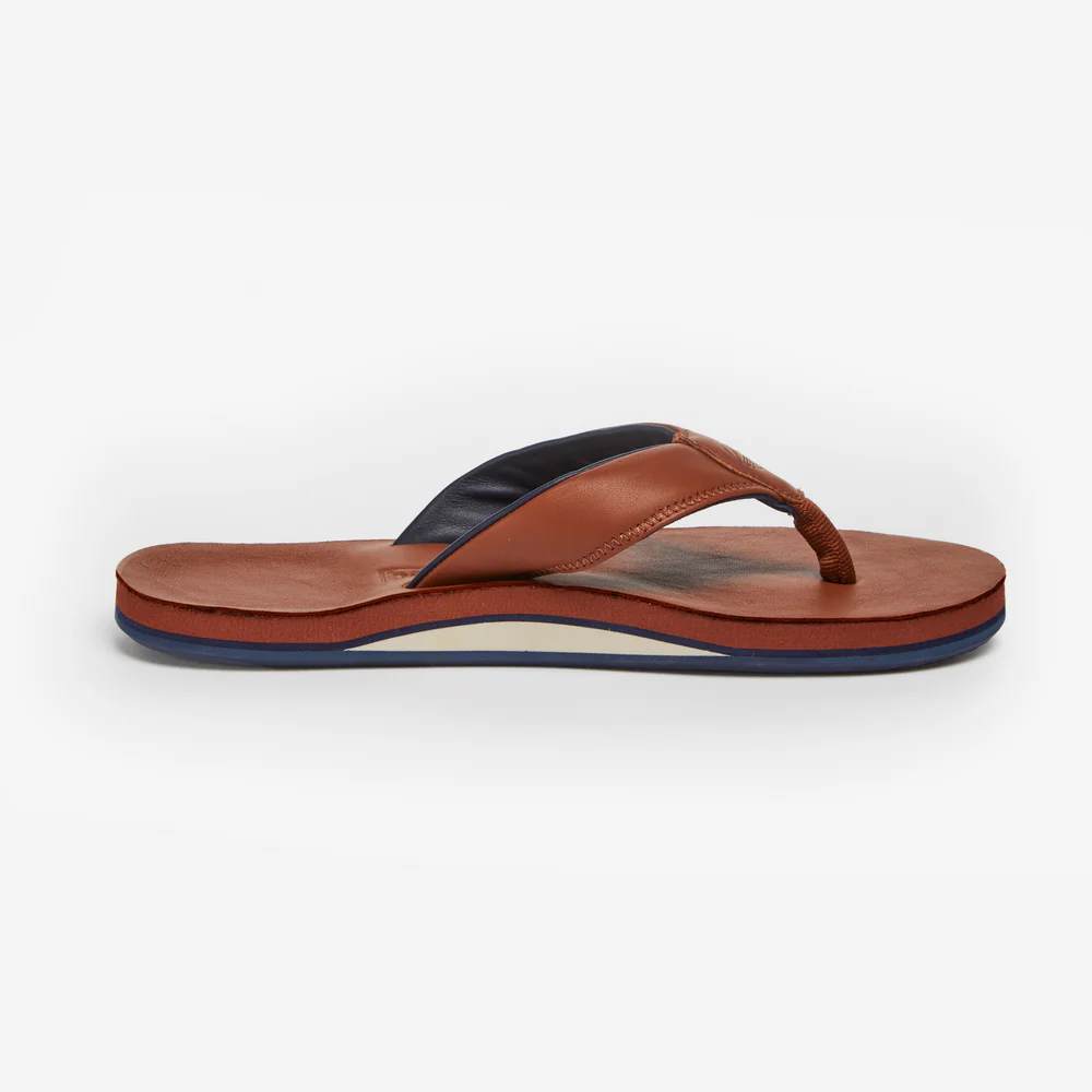 Brown sandal with a black strap on a white background