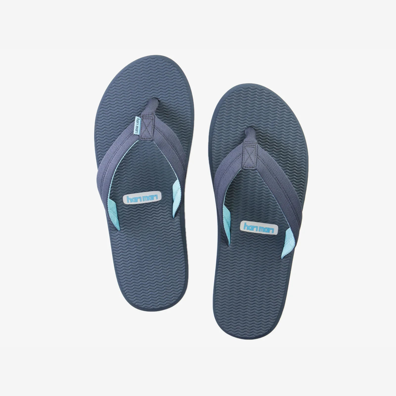 Pair of blue flip-flops with brand logo on a light gray background