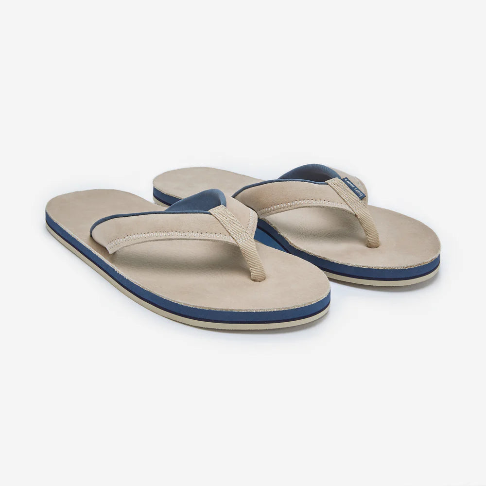 Pair of beige and navy flip-flops on a white background