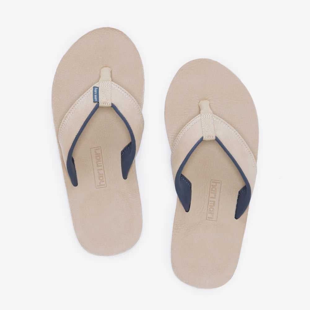 Beige flip-flops with navy straps on a white background
