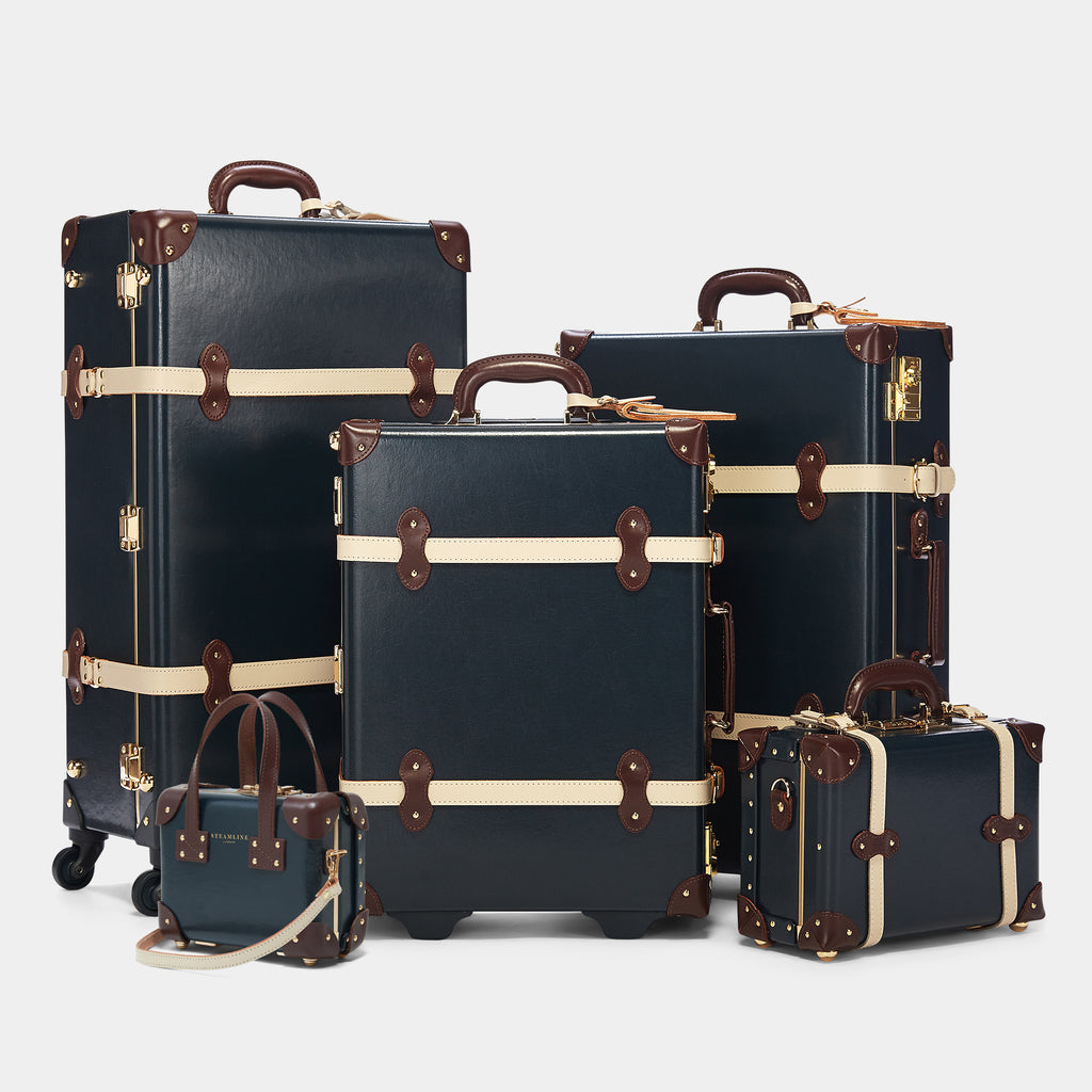 Set of navy blue suitcases with brown accents on a white background