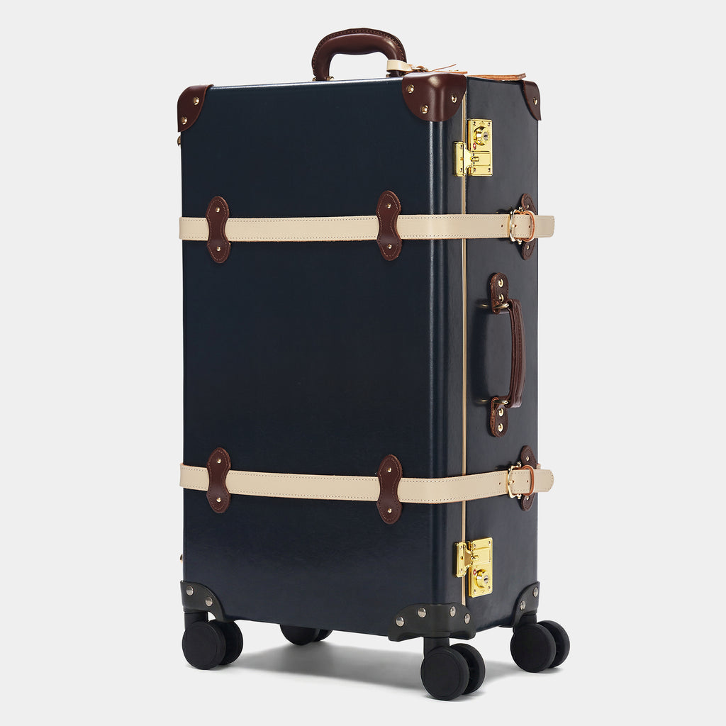 Vintage-style navy suitcase with brown accents on a light gray background