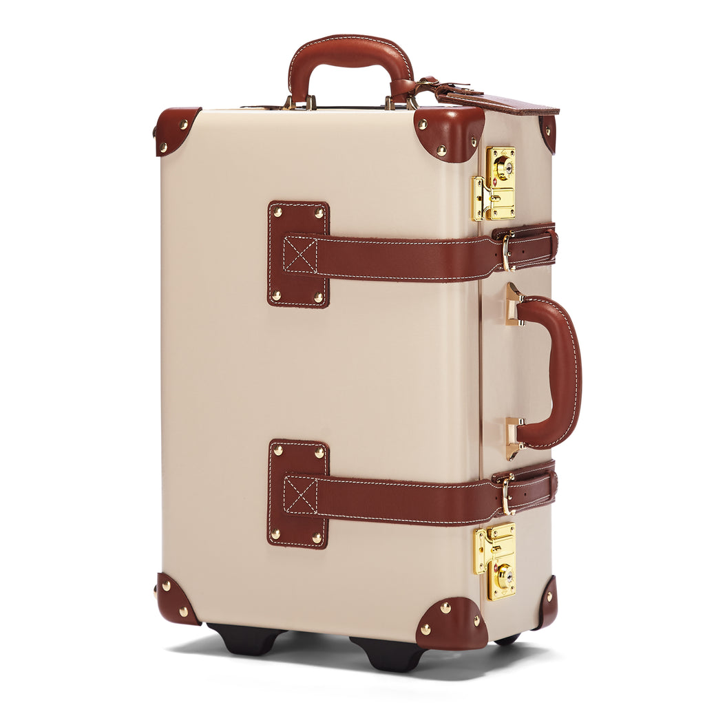 Beige suitcase with brown accents and gold locks on a white background