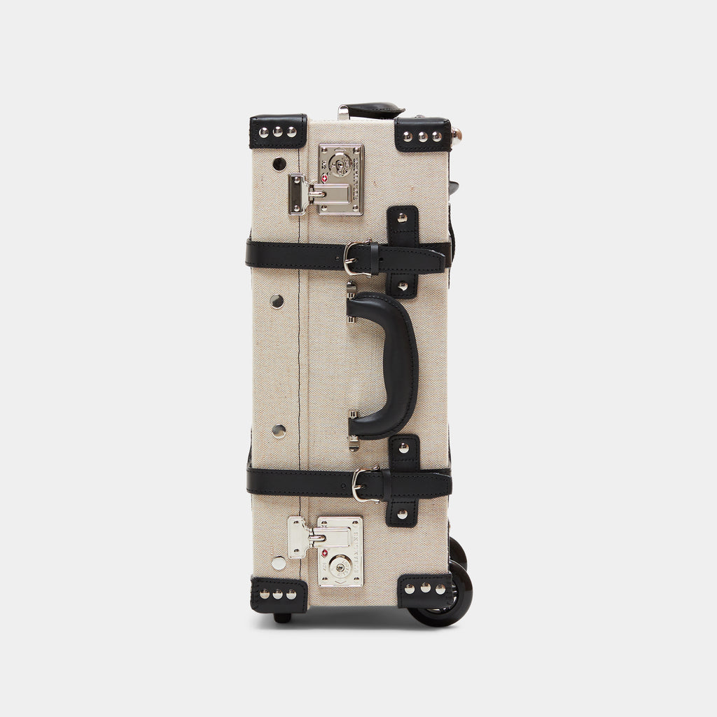 Beige suitcase with black accents on a light gray background