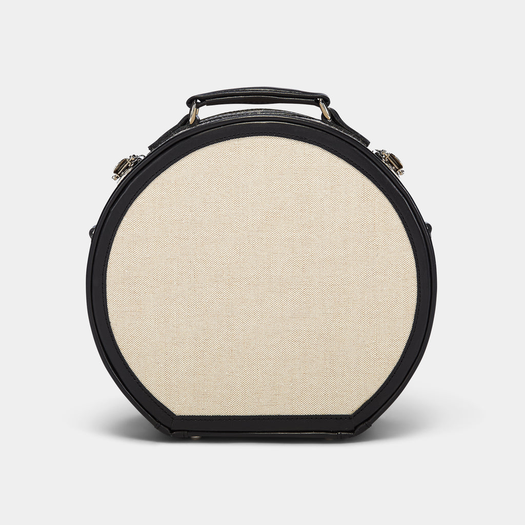 Round beige fabric case with black leather trim on a white background