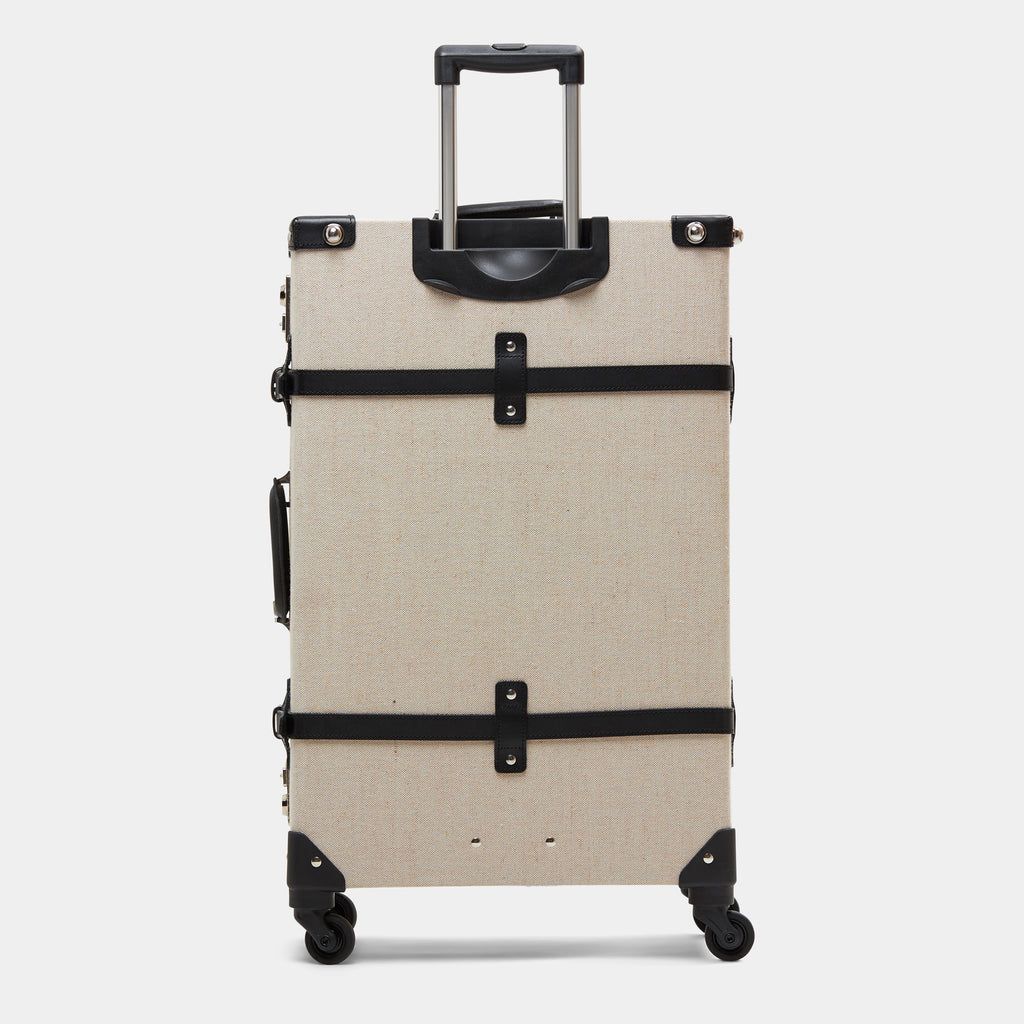 Beige suitcase with black straps on a white background