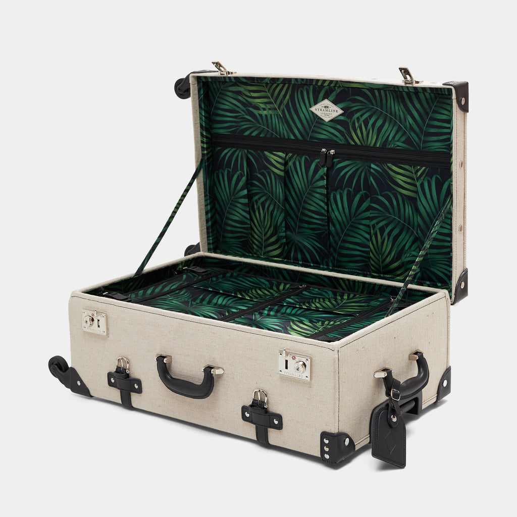 Open suitcase with green leaf pattern interior on a white background