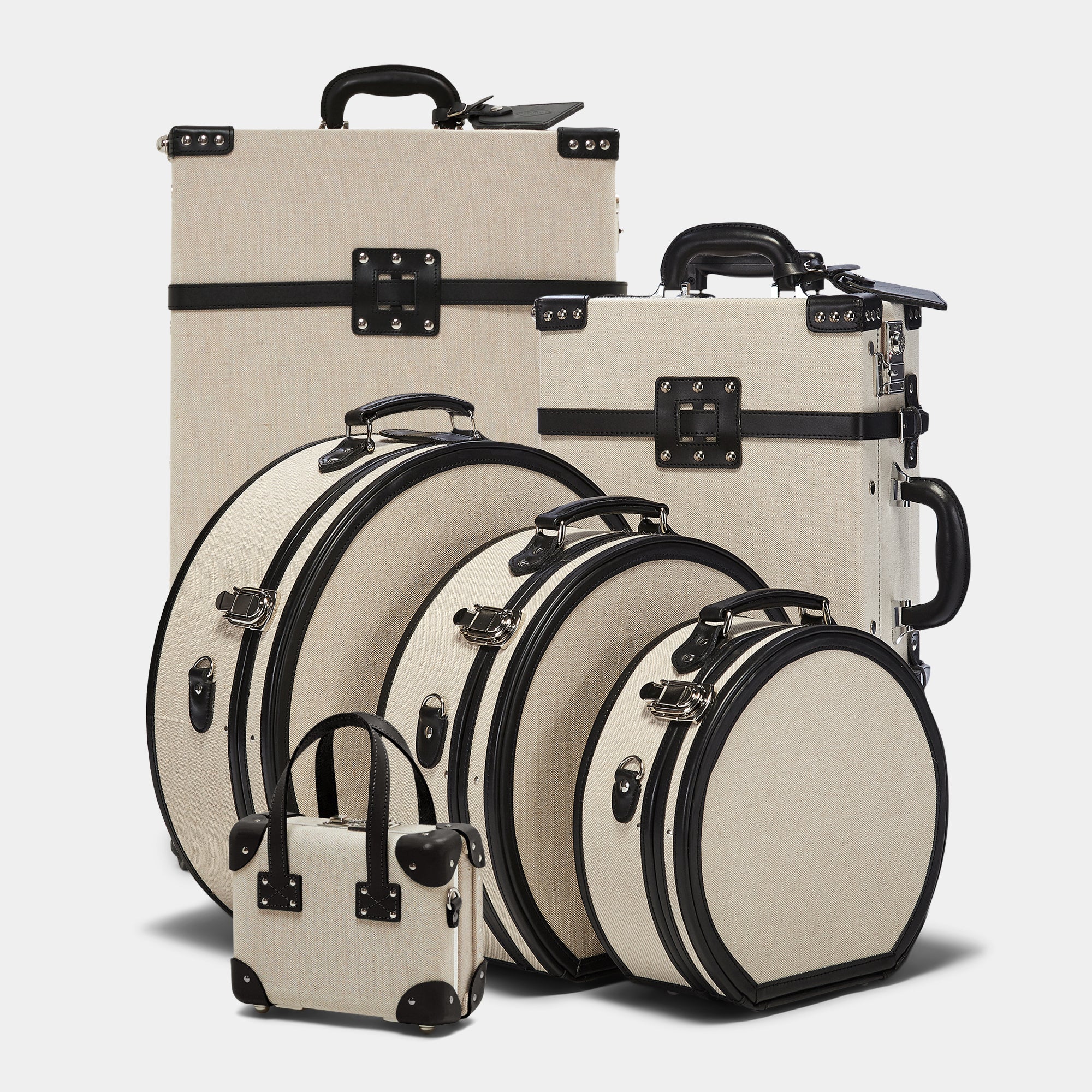 Set of beige suitcases with black handles and straps on a light gray background