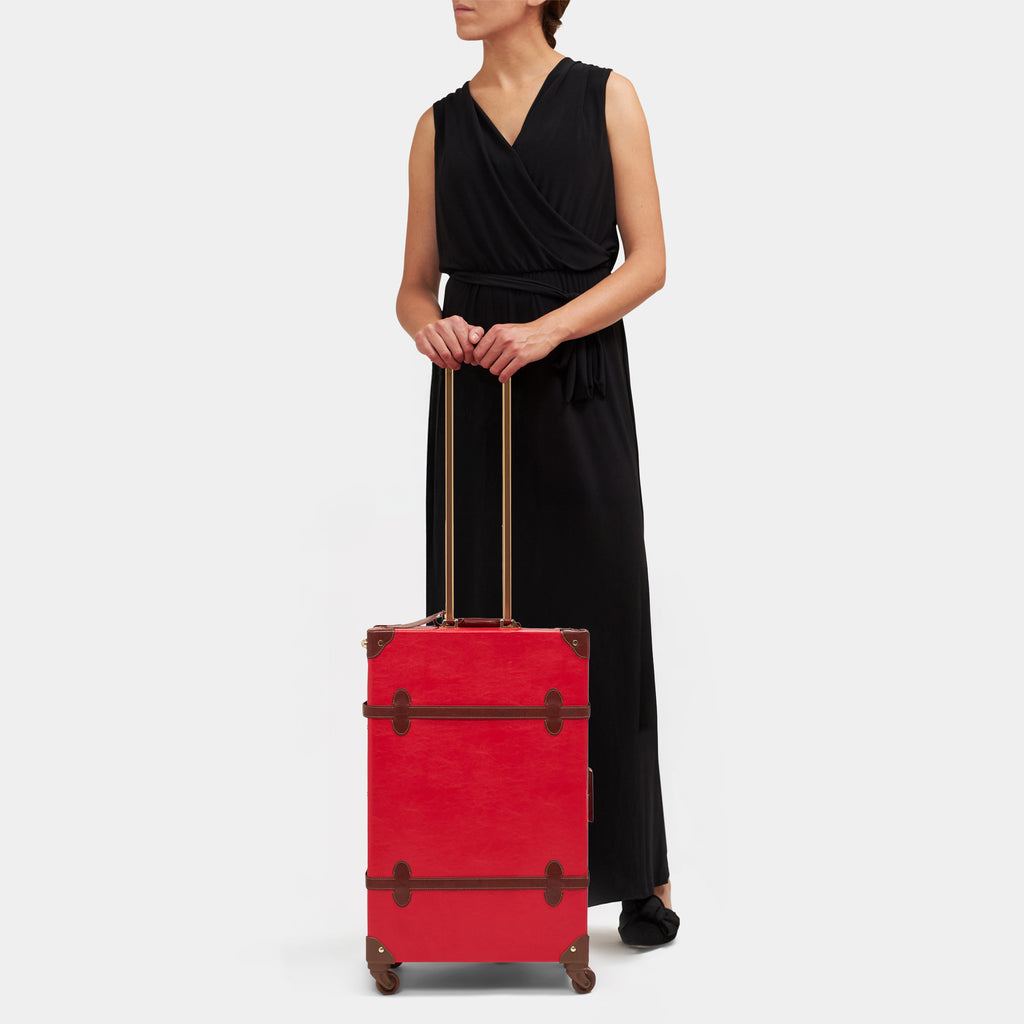 Woman holding a red suitcase on a white background