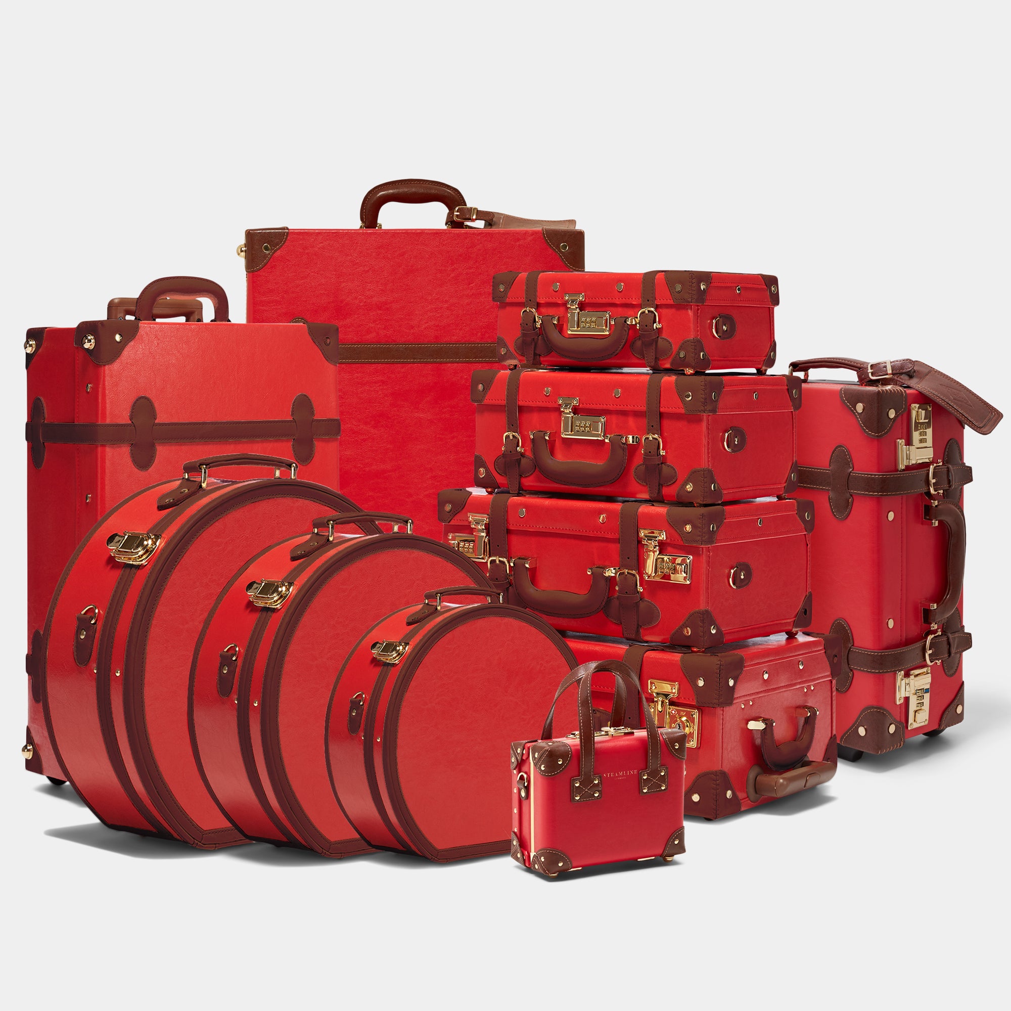 Set of red suitcases with brown accents on a white background