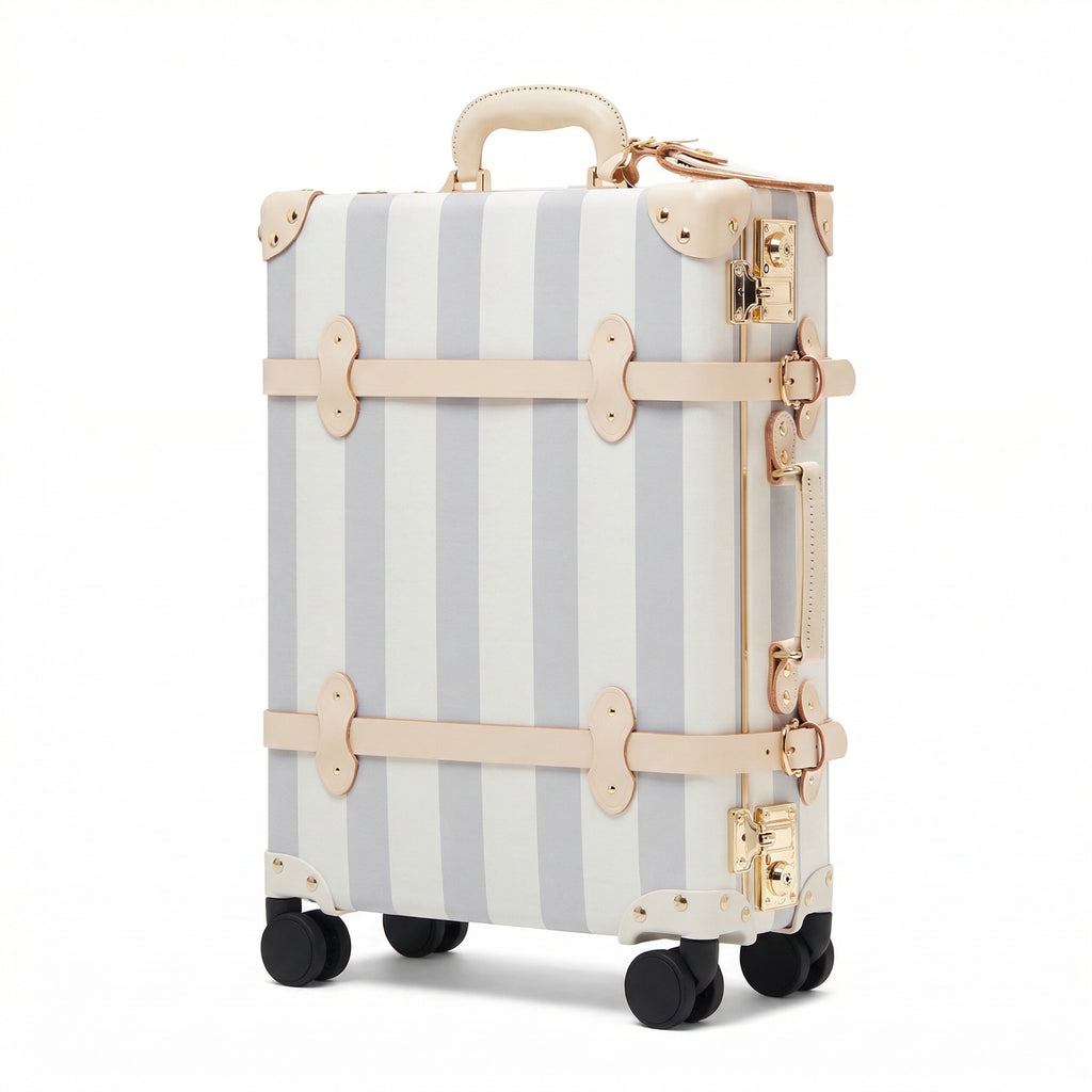Striped suitcase with gold accents on a white background
