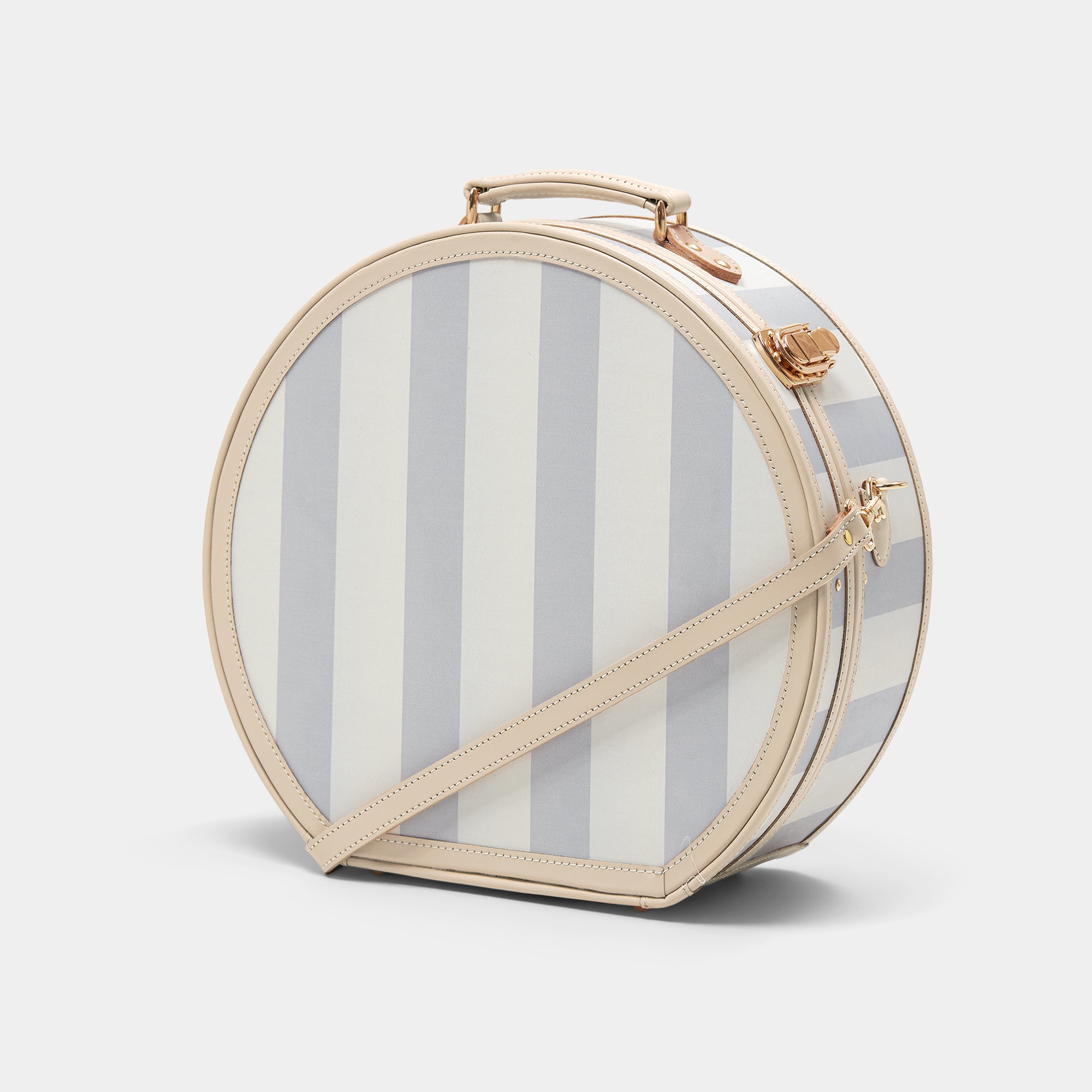 Round striped handbag with beige handle and strap on a white background