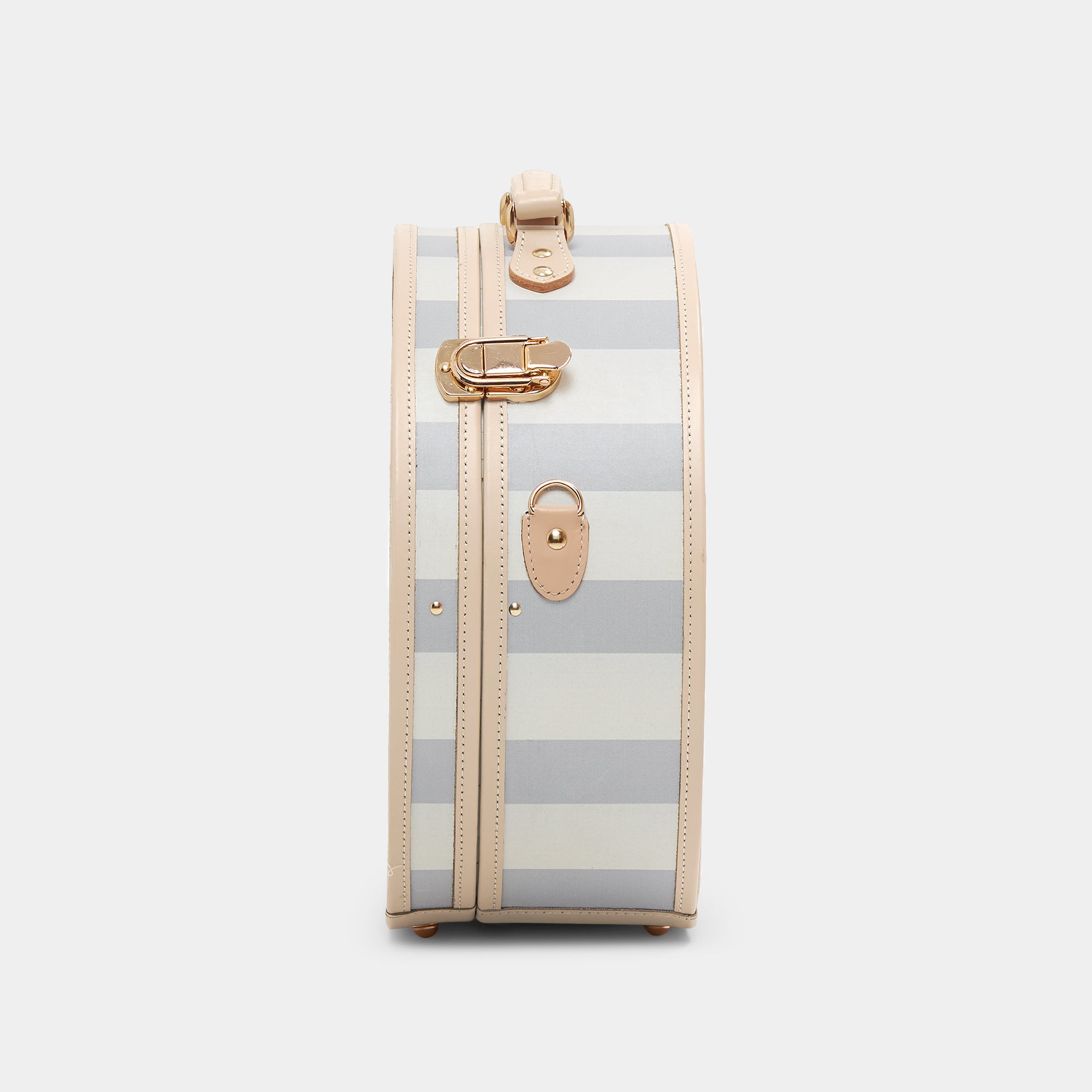 Striped suitcase with gold accents on a light gray background