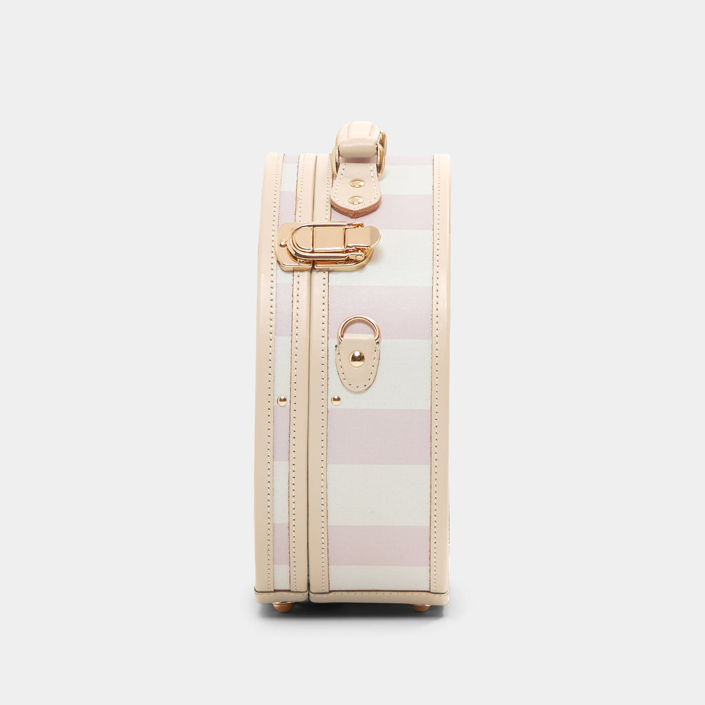 Small suitcase with gold accents on a light gray background