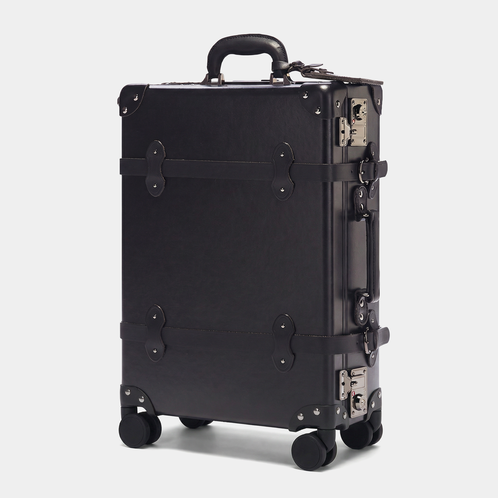 Black suitcase with metallic accents on a light gray background