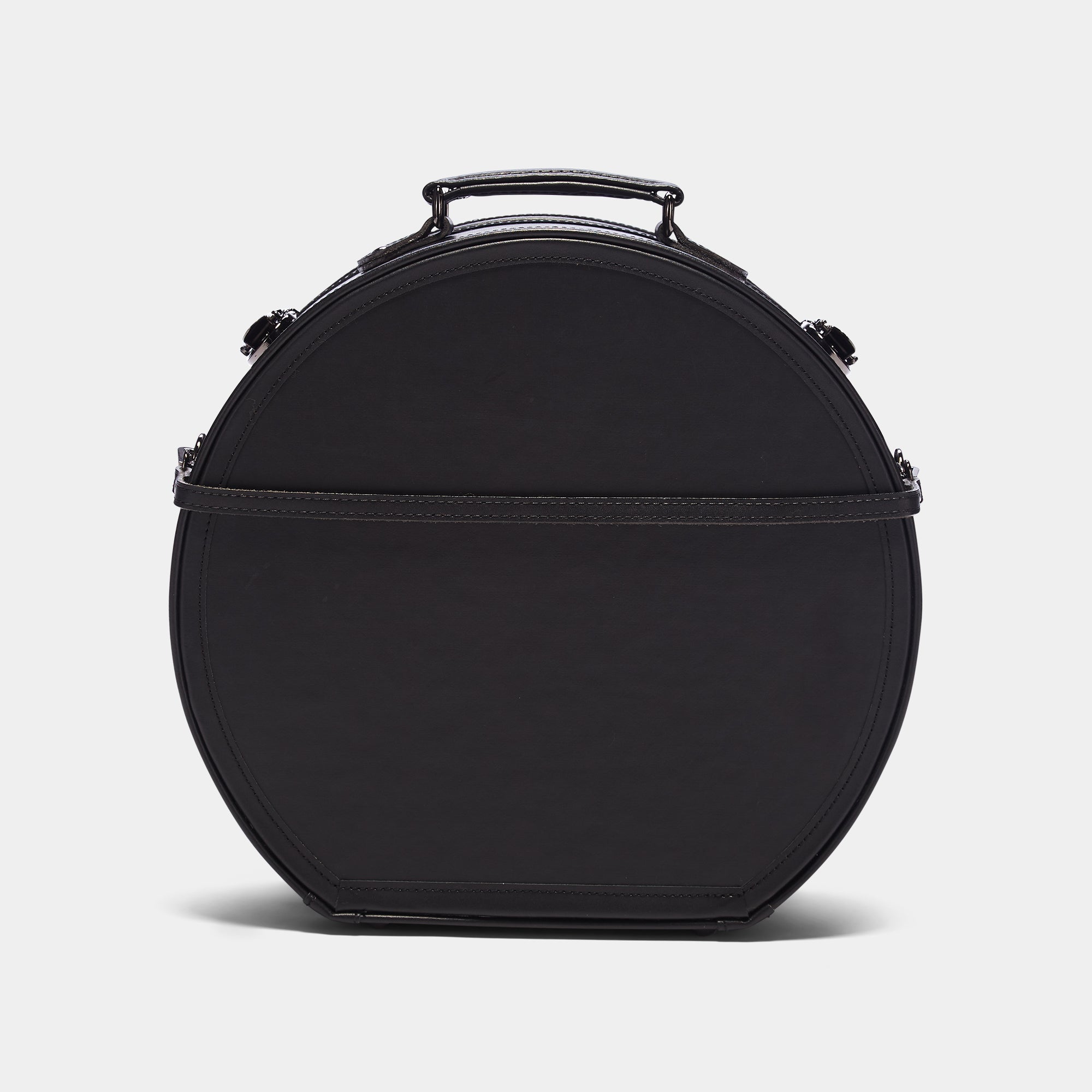 Black round hat Box bag with a handle on a light gray background