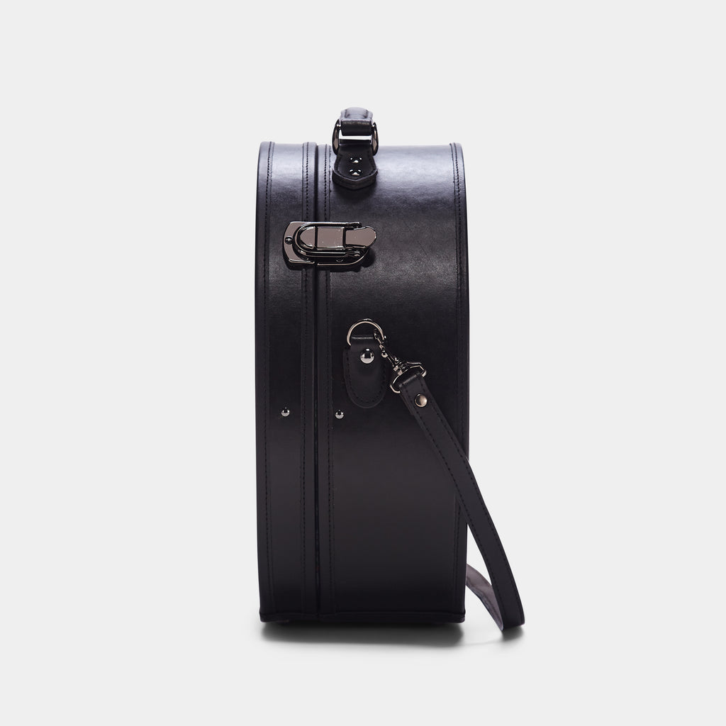 Black leather suitcase with a strap on a white background