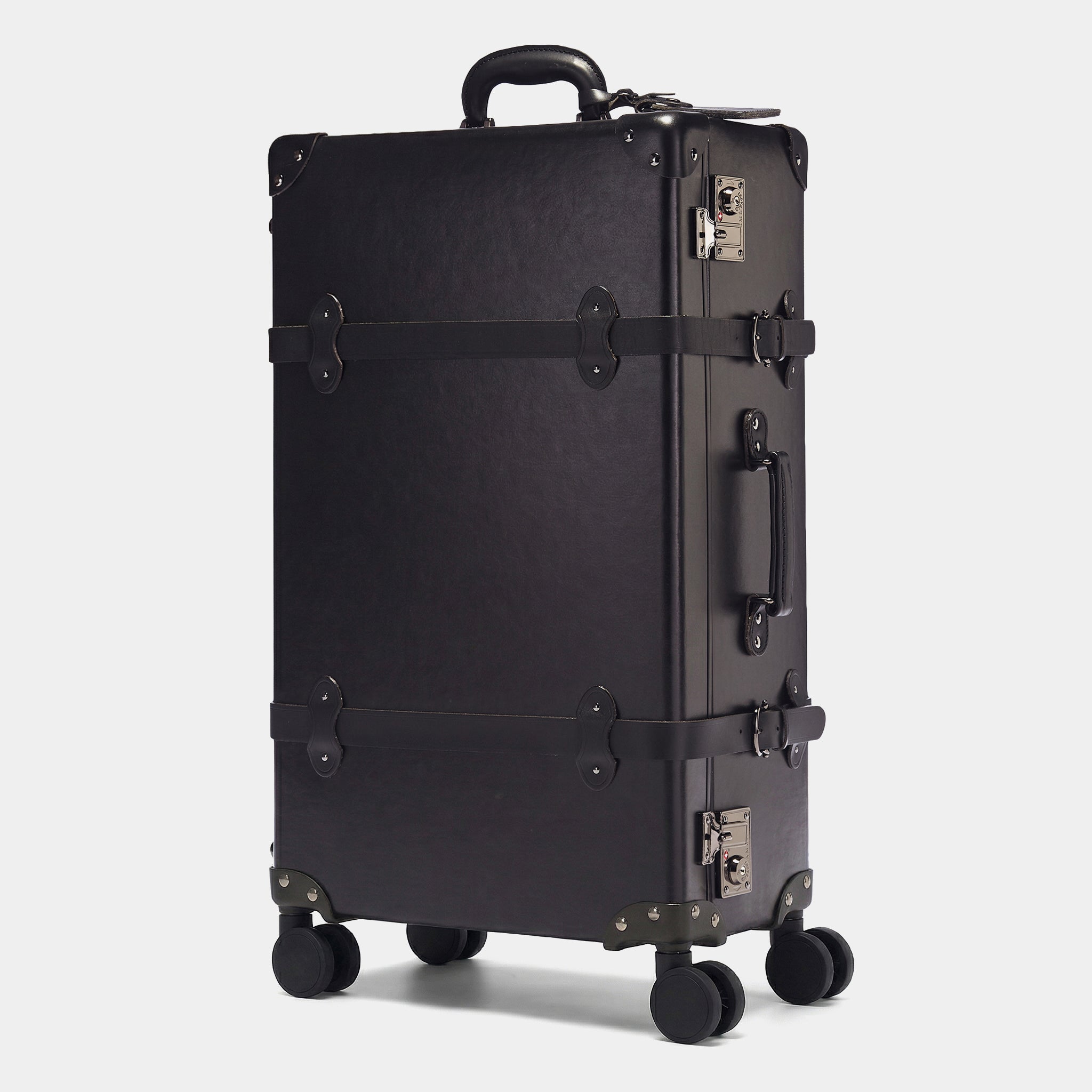 Black suitcase with wheels and handle on a light gray background