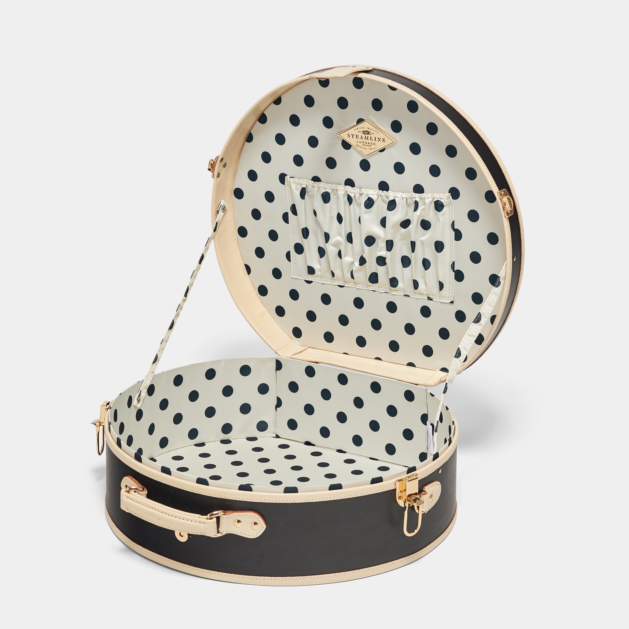 Black round suitcase with polka dot interior on a white background