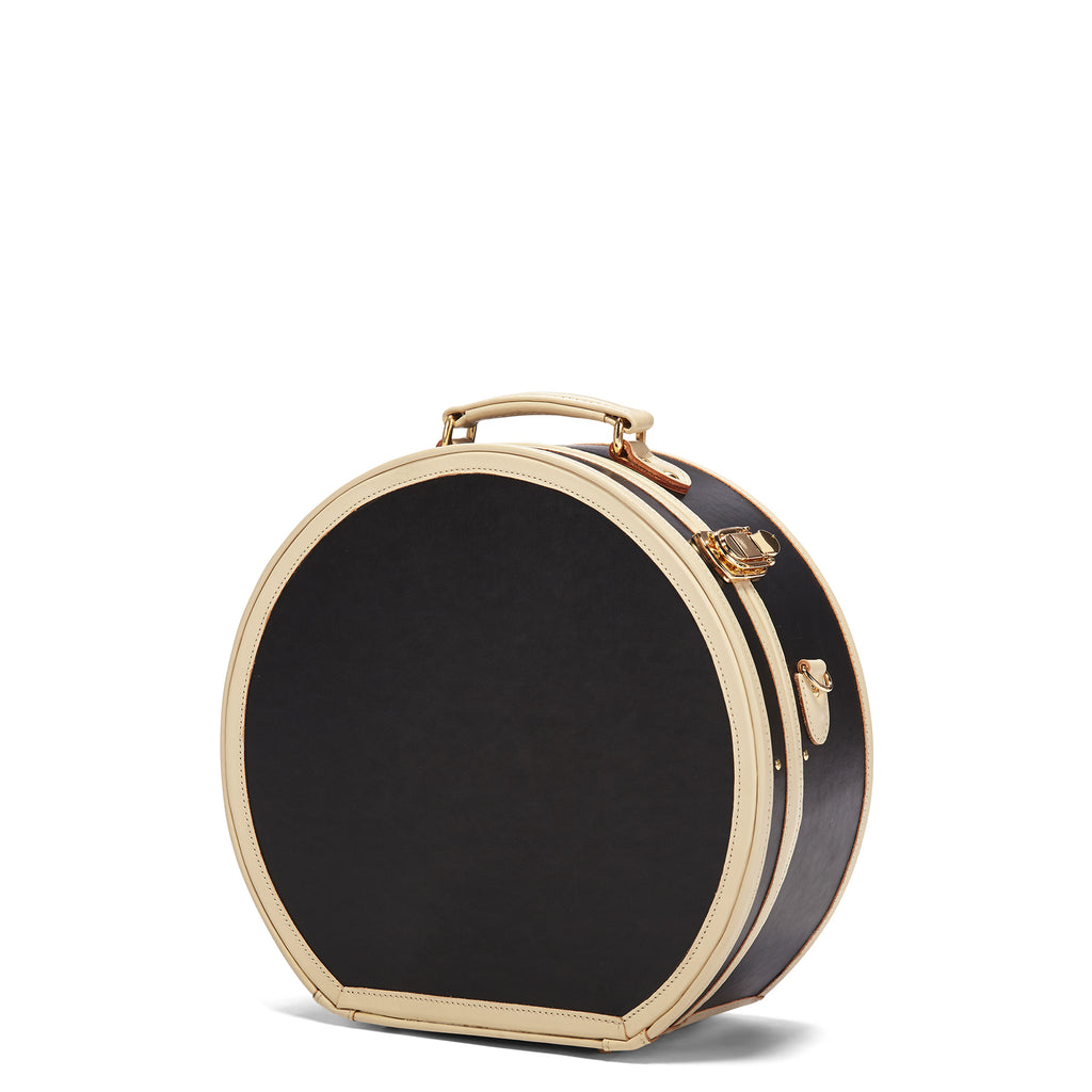 Round black handbag with gold accents on a white background
