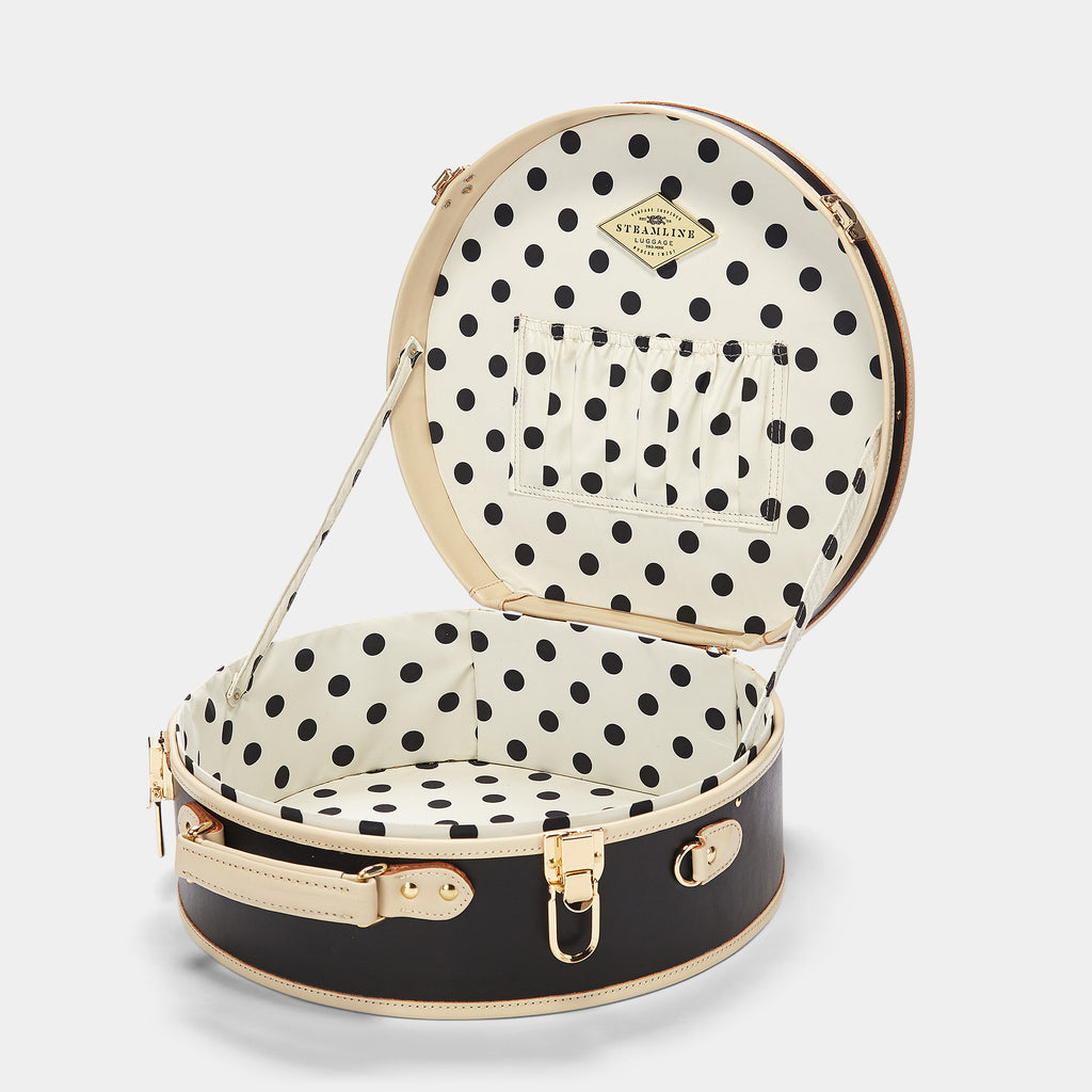 Black suitcase with a black and white polka dot lining on a white background
