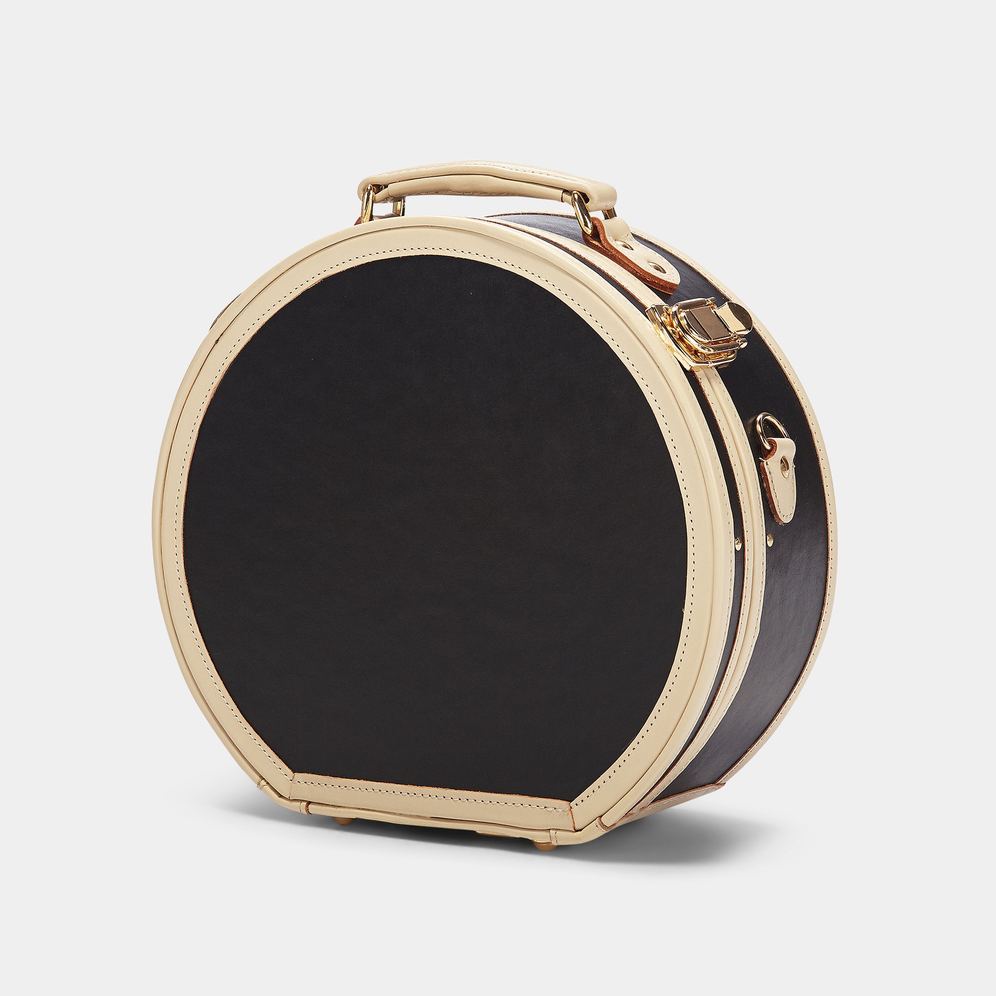 Round black and gold travel case on a light gray background