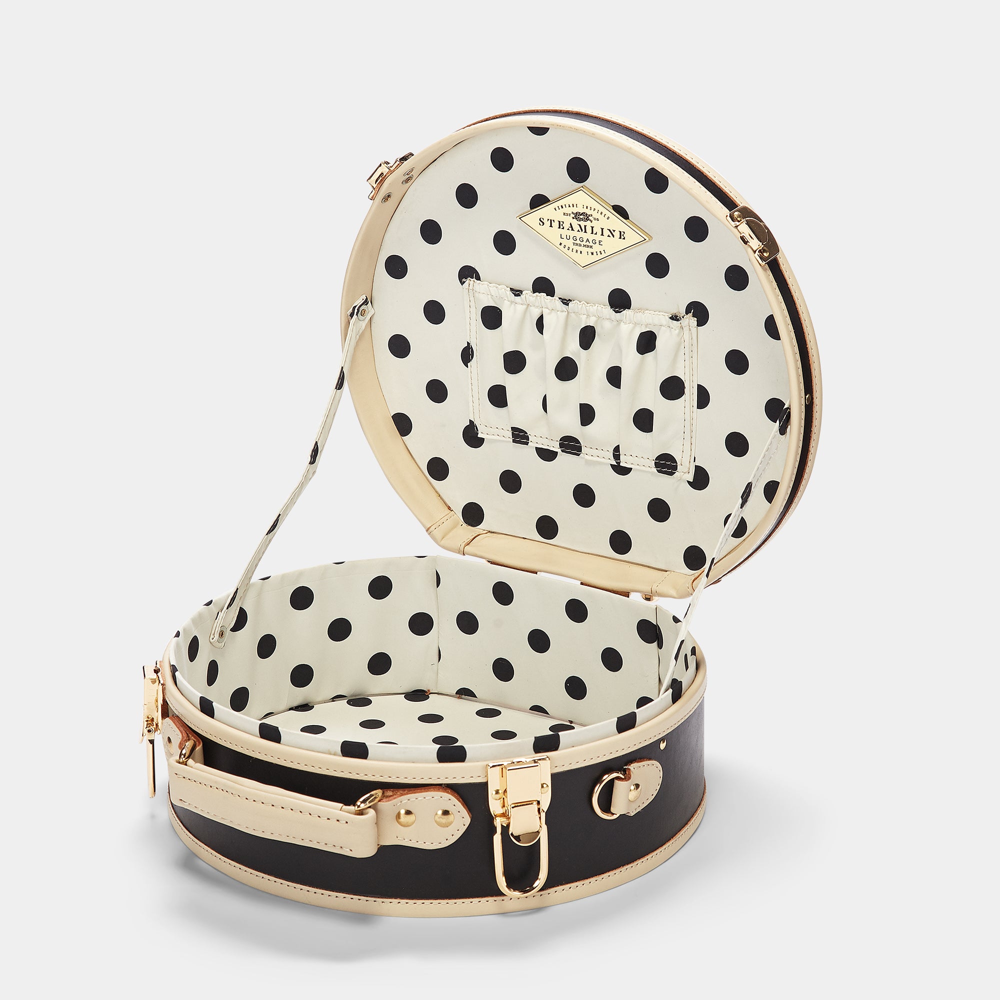 Interior shot of suitcase with open lid and polka dot lining on a light gray background