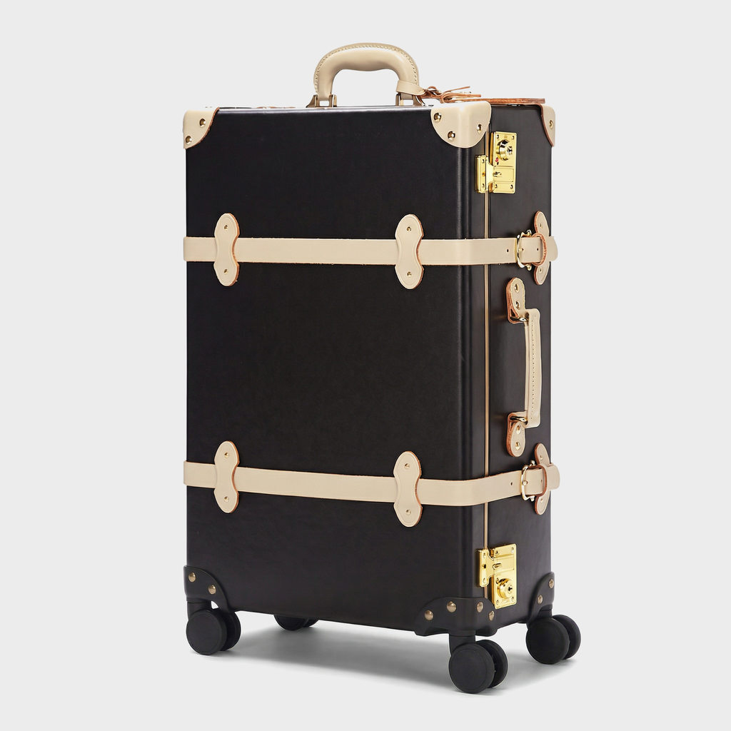 Black suitcase with gold accents on a light gray background