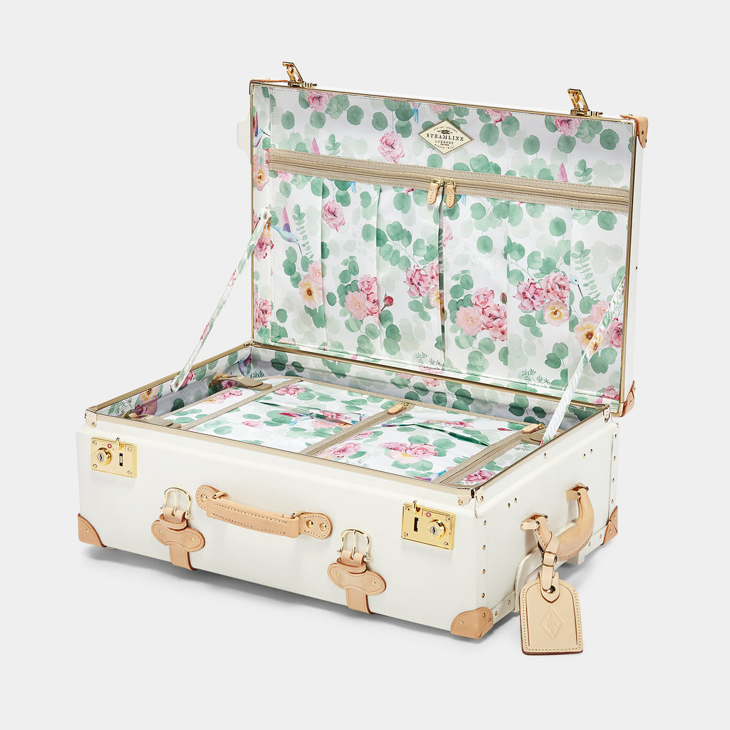 Floral-patterned suitcase with gold accents on a white background
