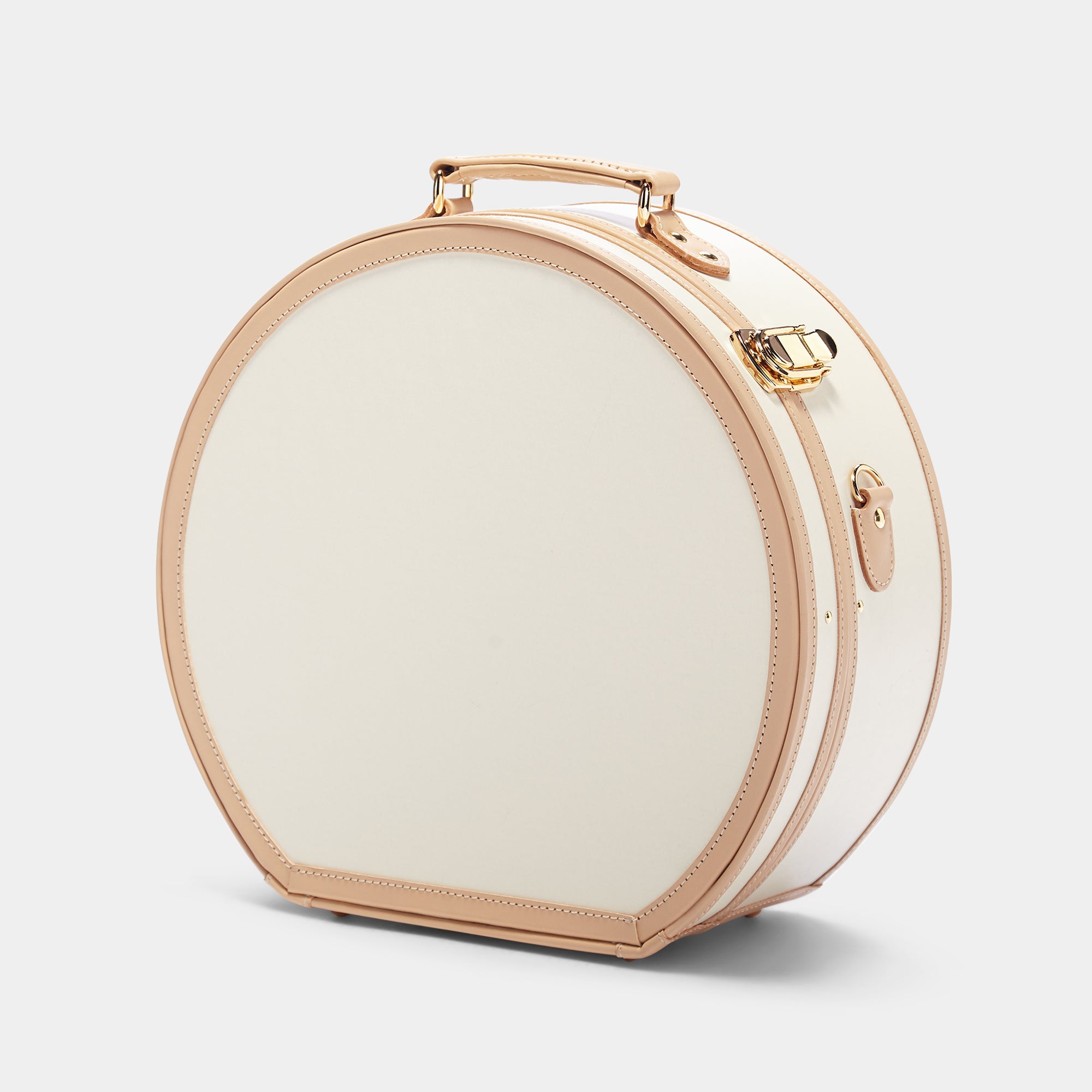 Round beige travel case with gold accents on a light gray background