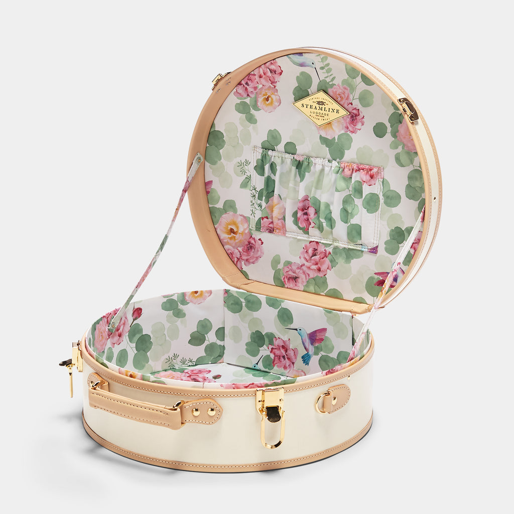 Round floral-patterned suitcase with open lid on a white background