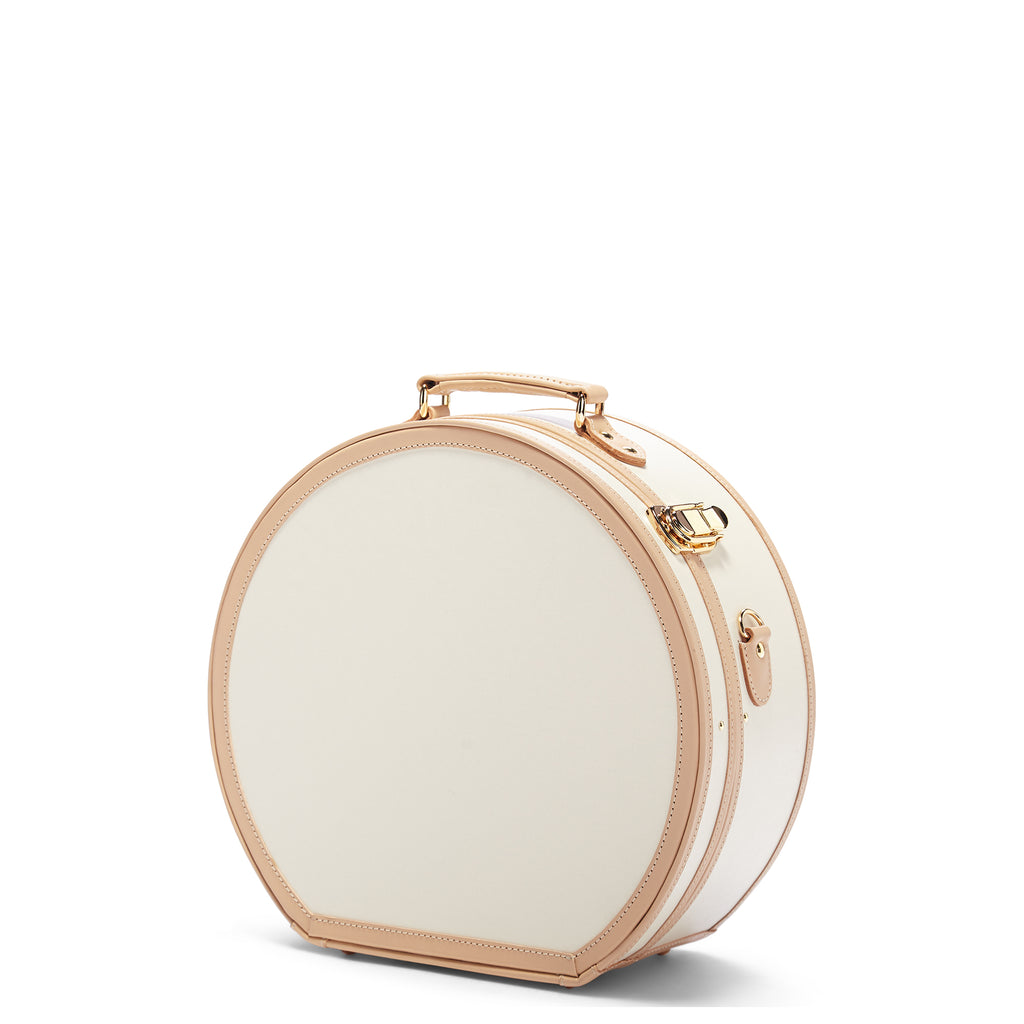Round white beauty case with gold accents on a white background