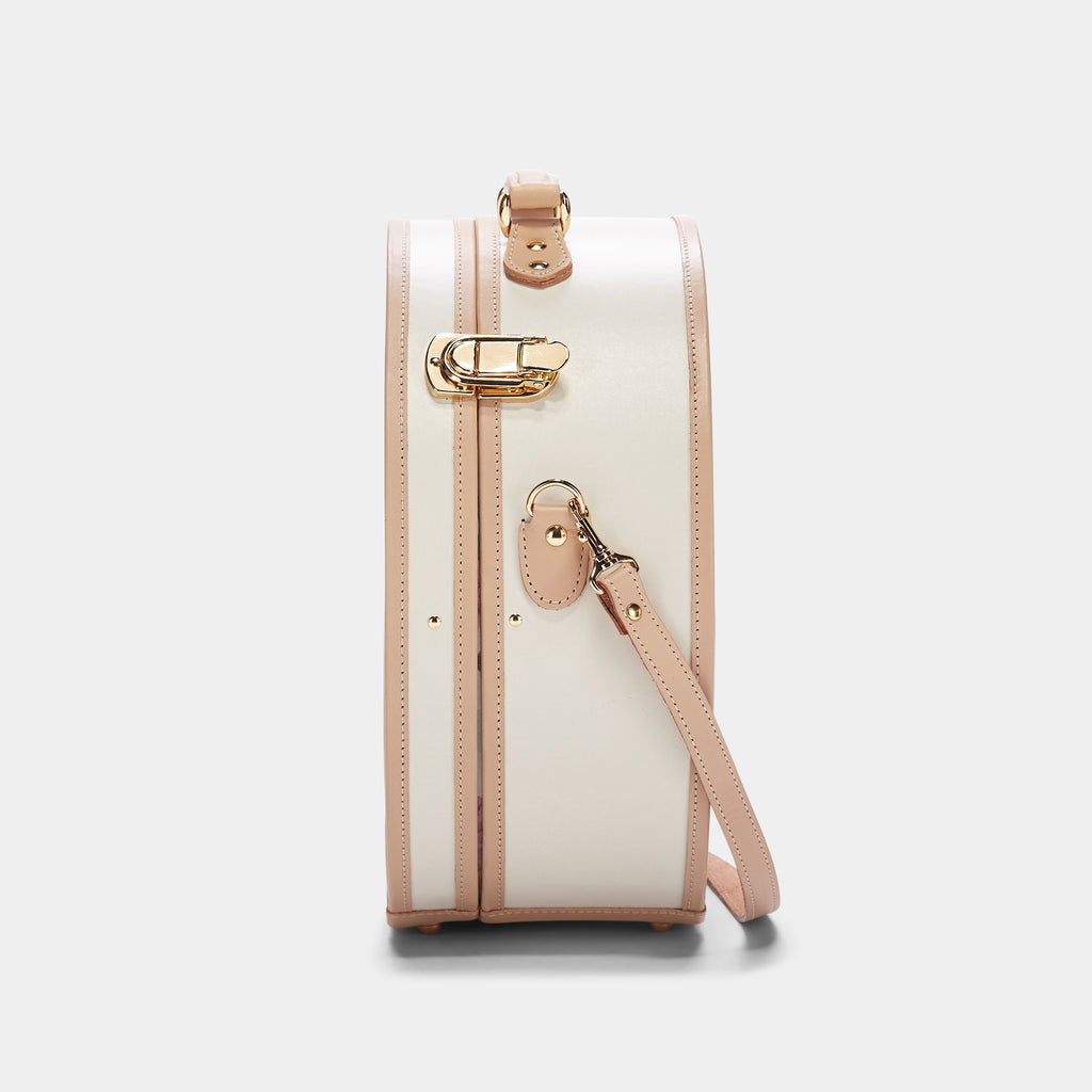 White handbag with pink accents on a light gray background