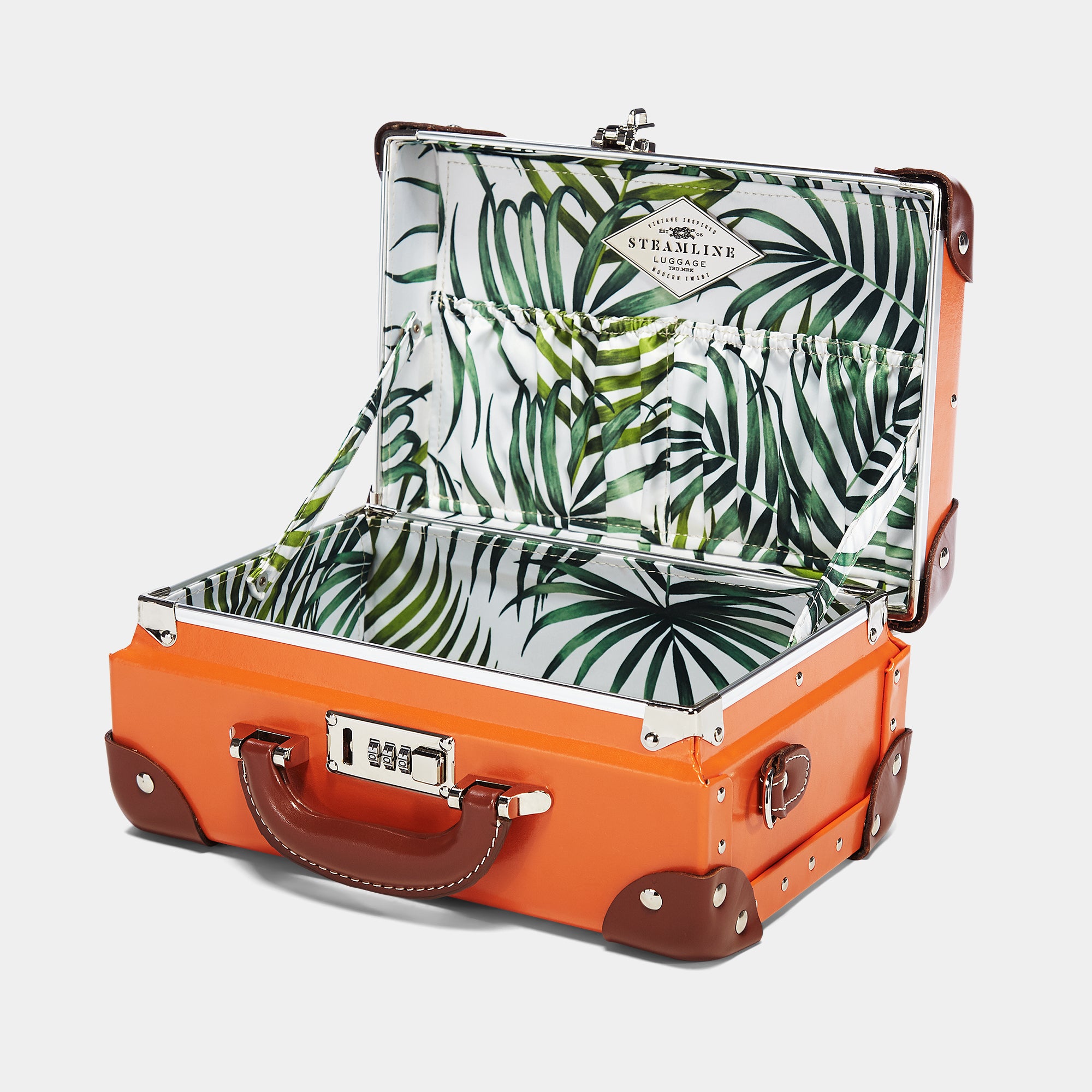 Orange suitcase with tropical leaf pattern interior on a white background