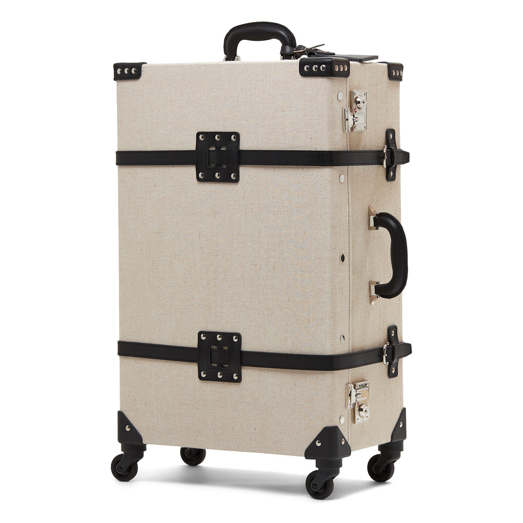 Beige linen suitcase with black straps and wheels on a white background