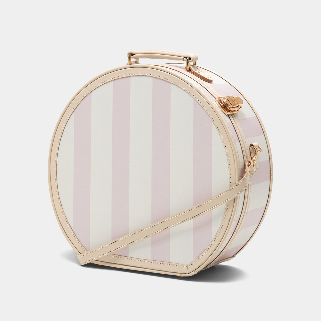 Round striped handbag with a gold handle and strap on a light gray background