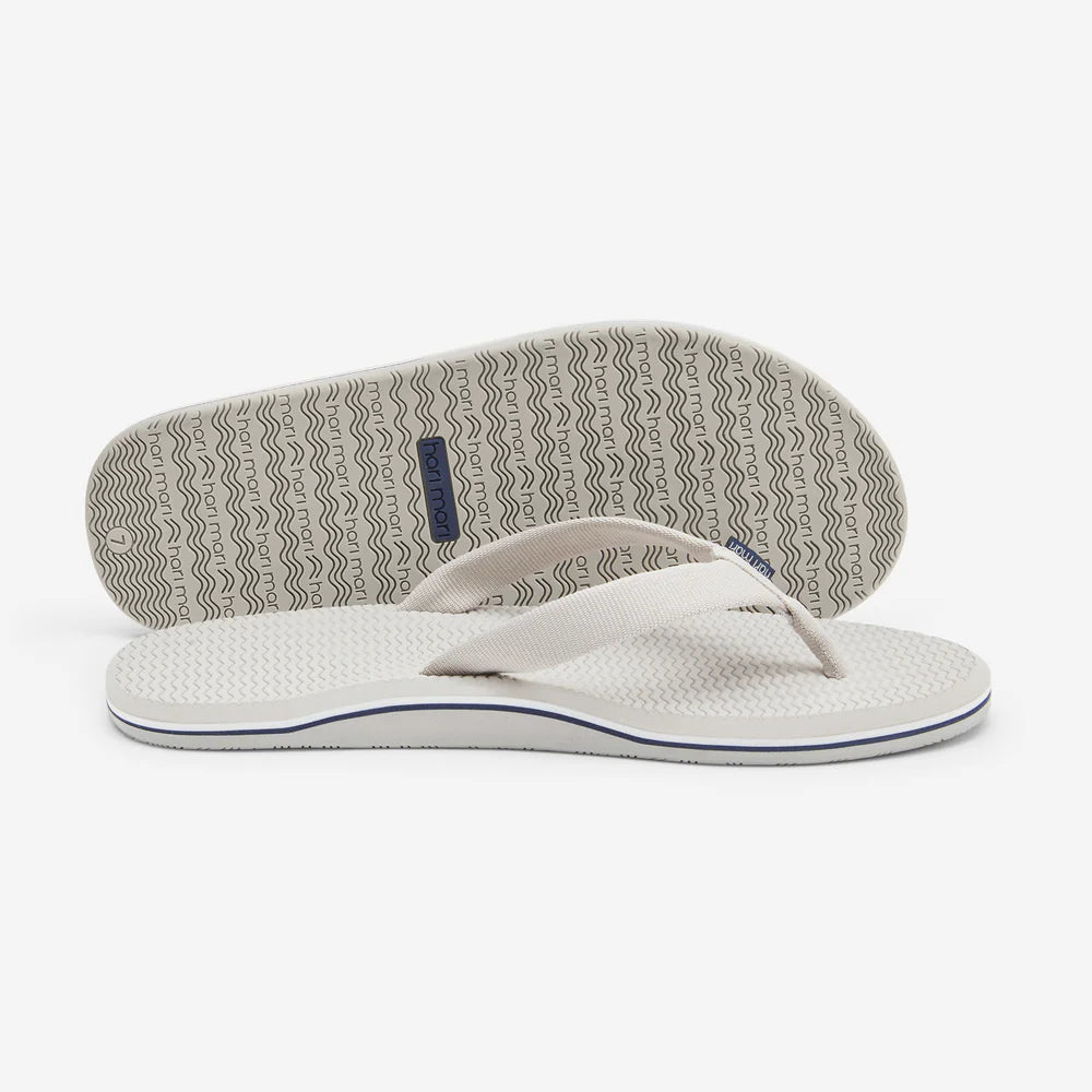 White flip-flop sandal with a textured sole on a white background