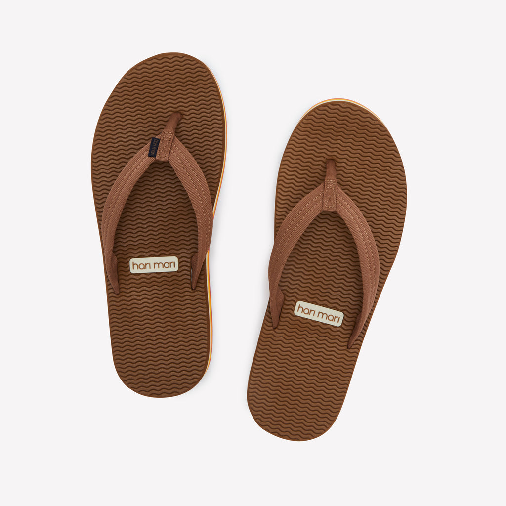 Pair of brown flip-flops with a visible brand logo on a white background