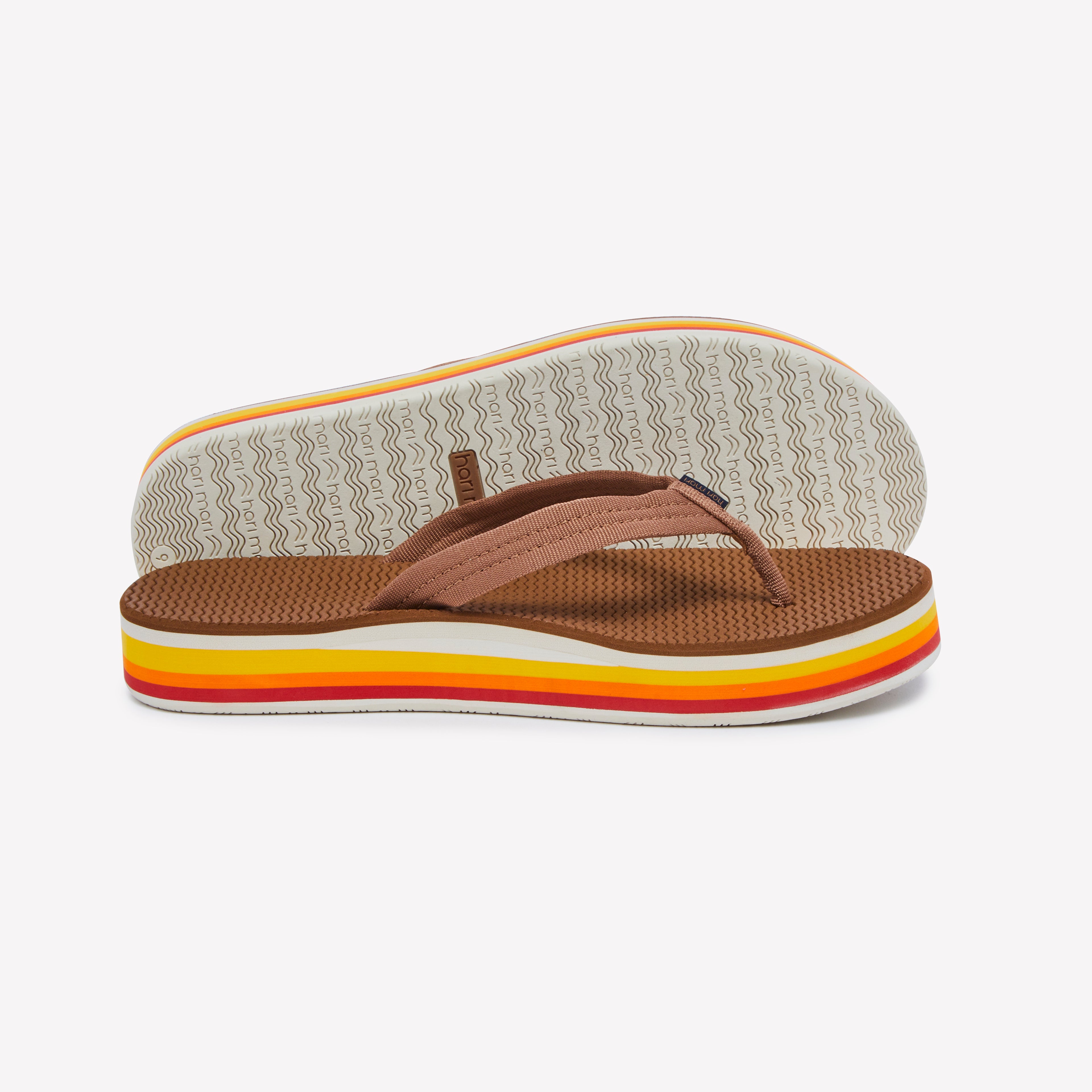 Brown sandal with colorful sole on a white background