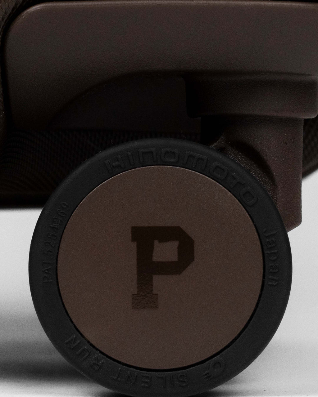 Close-up of a suitcase wheel with a brand logo on a white background